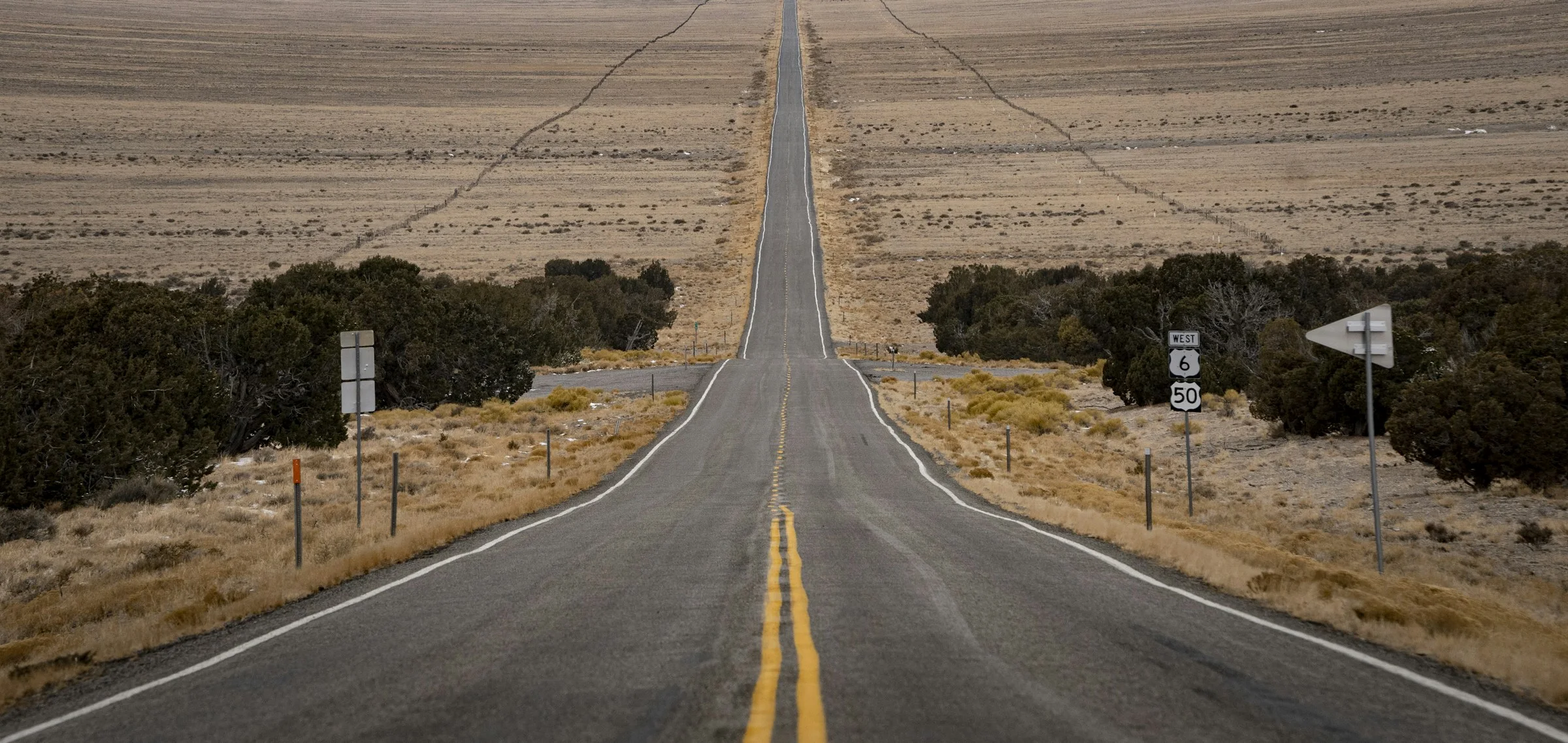 Long highway crossing an expansive desert landscape